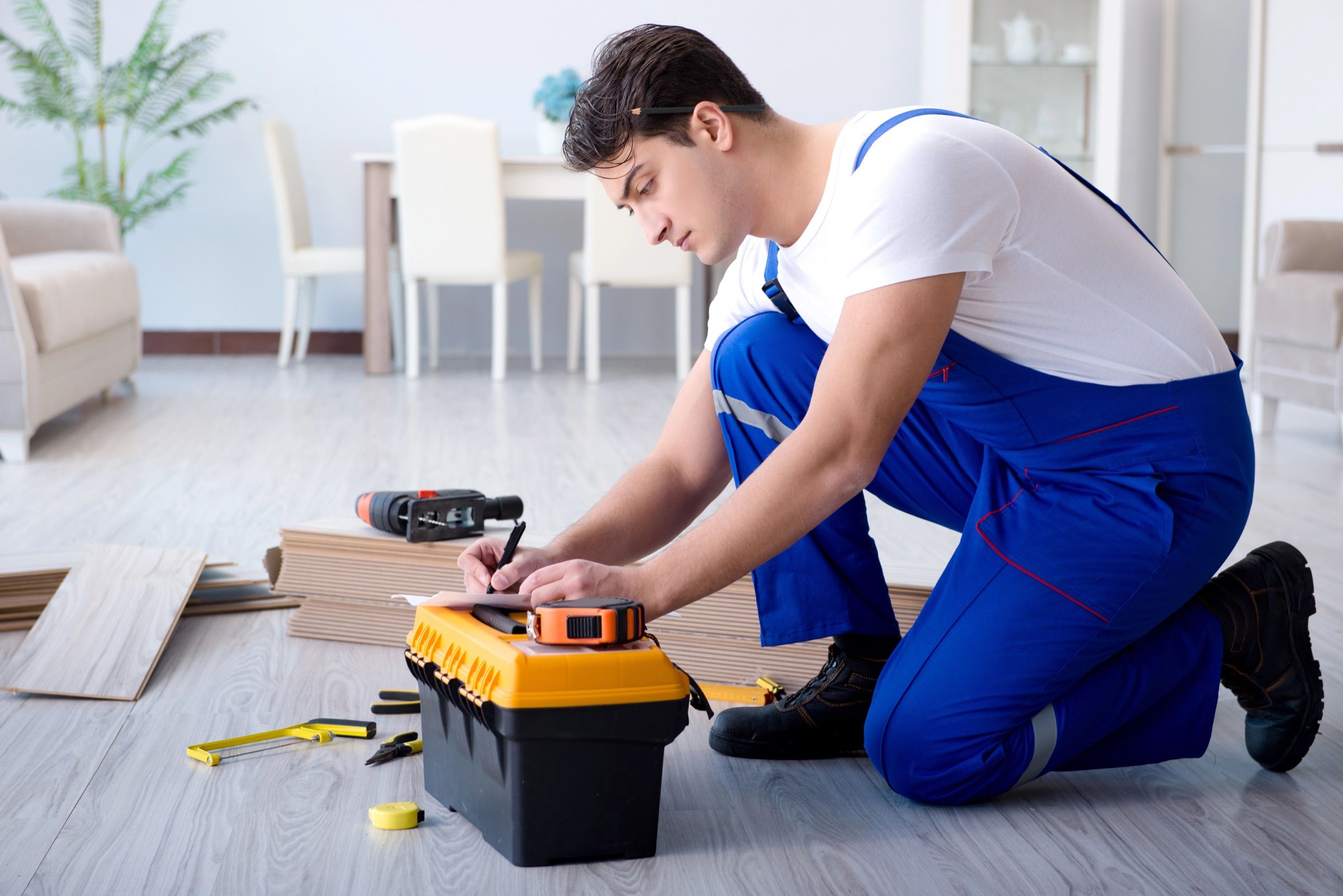 Meșter care măsoară parchetul într-un apartament în renovare